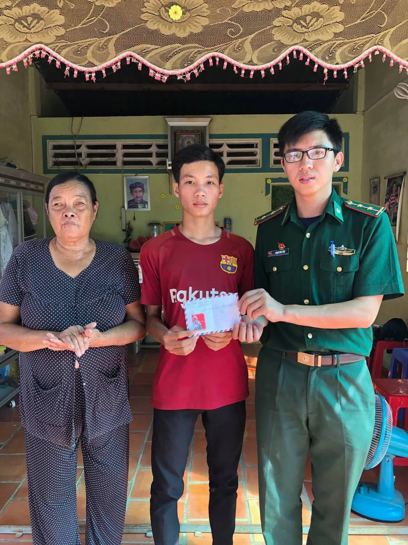 Nguyễn Văn Đễ with his grandmother and a community supporter