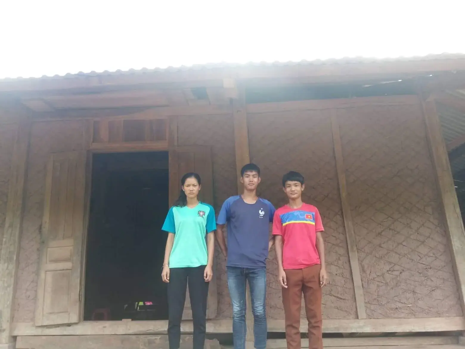 Lỳ Kiên Hoà standing with supporters outside his home